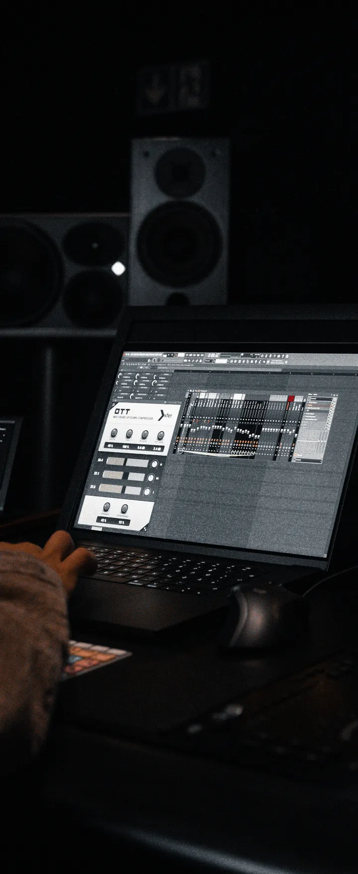 Laptop mit geöffnetem Plugin im Studio, Hand an der Tastatur